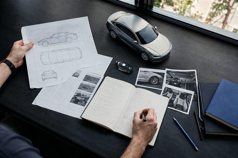 Automotive editor comparing specifications, notes and photographs